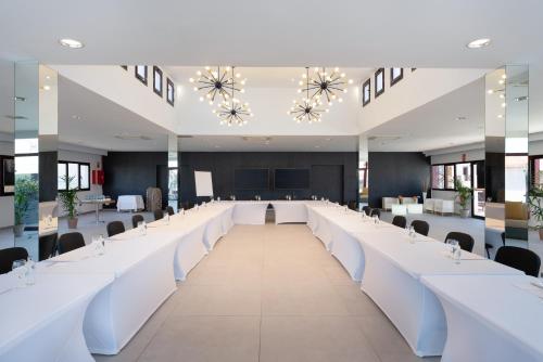 a large conference room with white tables and chairs at Occidental Roca Negra - Adults Only in Agaete