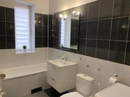 a bathroom with a toilet and a sink and a tub at APARTAMENT GERSONA in Bydgoszcz
