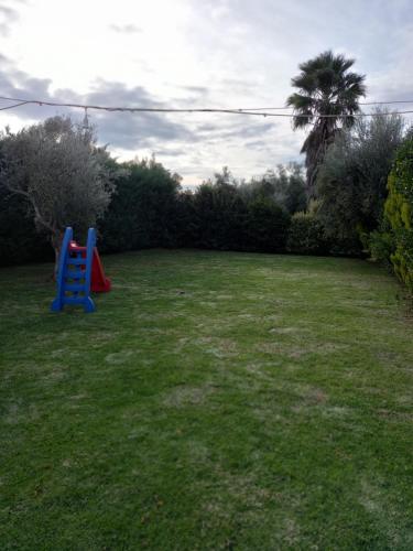 a playground with a blue slide in a yard at Phaedra Electra Estate in Tsoukalaíika