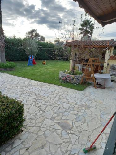 a stone patio with a playground and a house at Phaedra Electra Estate in Tsoukalaíika