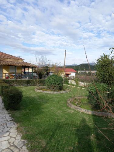 a yard with a house in the background with a yardablish at Phaedra Electra Estate in Tsoukalaíika