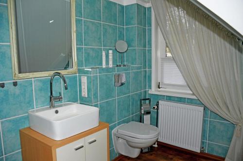 een badkamer met een wastafel en een toilet bij Reetdachfachwerkvilla am Wiesengrund in Bergen auf Rügen