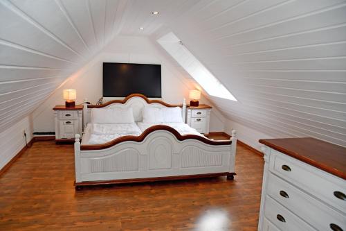 een slaapkamer met een wit bed op zolder bij Reetdachfachwerkvilla am Wiesengrund in Bergen auf Rügen