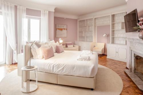 ein Schlafzimmer mit einem weißen Bett und einem Kamin in der Unterkunft Luzeiros Suites in Lissabon