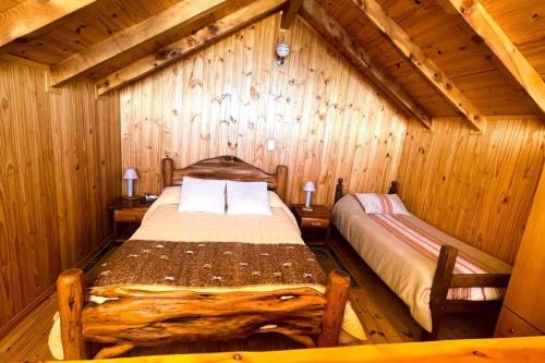 um quarto com uma cama num chalé de madeira em Casa de Montaña Cerro Otto. Aventurate! em San Carlos de Bariloche