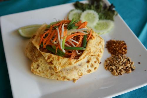 a white plate with a tortilla with carrots and other vegetables at Baan Kiao in Haad Yao