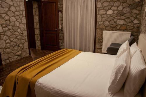 a bedroom with a bed with a yellow blanket on it at PS House Polydrosos - PS Rental in Polydrossos