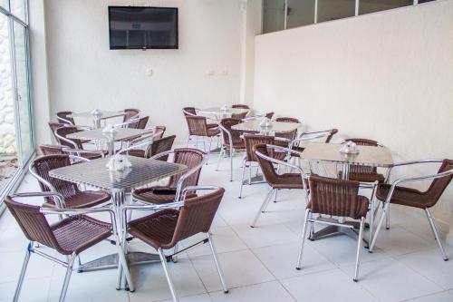 a group of tables and chairs in a room at Victoria Imperial Hotel in Mariquita