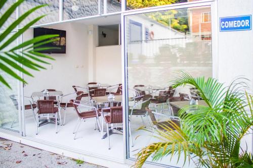 a patio with tables and chairs outside of a restaurant at Victoria Imperial Hotel in Mariquita