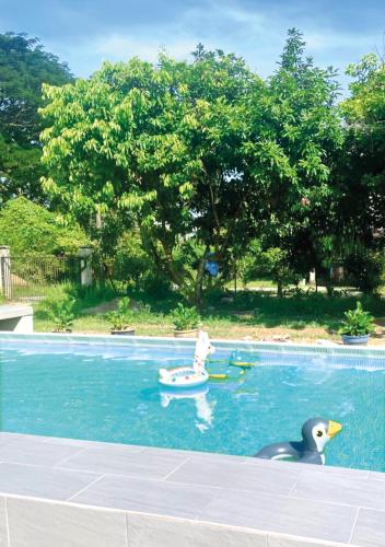 a duck and a rubber ducky and a child in a boat in a pool at Villa Ruby - with private swimming pool in Kota Bharu