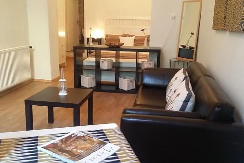 un soggiorno con divano in pelle e tavolo di AIRAM Apartment CENTER BUDAPEST a Budapest