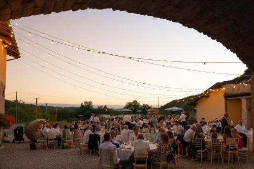 un grupo de personas sentadas en mesas en una fiesta en Cascina Formighezzo, en Arquata Scrivia