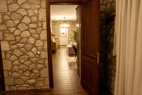 a hallway with a stone wall and an open door at PS House Polydrosos - PS Rental in Polydrossos