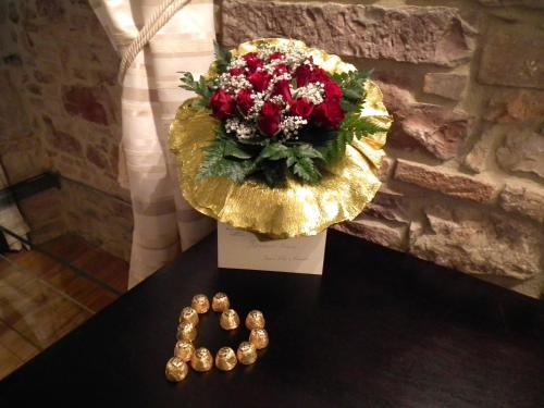 a table with a bouquet of red flowers and beads at Case Brizi Assisi in Assisi