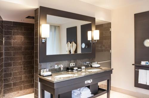 a bathroom with a sink and a mirror at AlpenGold Hotel Davos in Davos
