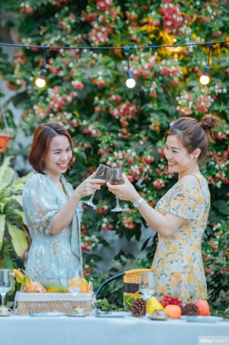 two women are holding up glasses of wine at Tuan Nam Homestay in Ninh Binh