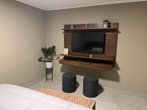 a living room with a television and two stools at Avalon Apartments in Puerto Iguazú