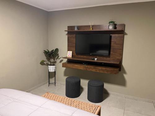 sala de estar con TV y 2 taburetes en Casa Céntrica para alquiler vacacional en Puerto Iguazú