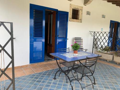 Residence Salvatore في San Salvatore: طاولة زرقاء وكرسي أمام باب