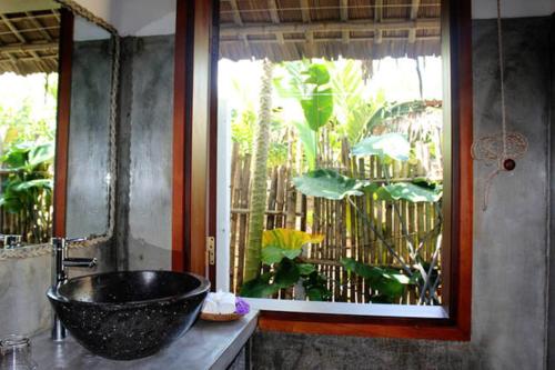 baño con lavabo de tazón negro y ventana en An Bang Hideaway, en Hoi An