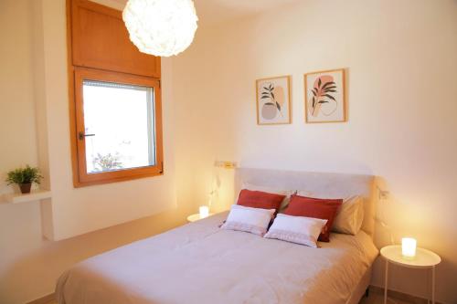 een slaapkamer met een bed met 2 kussens en een raam bij Meir Dizengoff Residence with Shelter in Tel Aviv