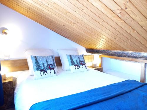 a bed in a room with a wooden ceiling at Chalet de montagne au cœur de Doucy in Doucy