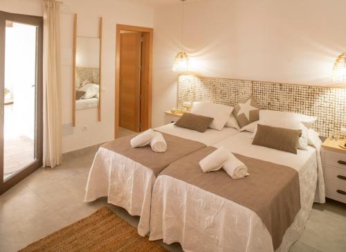 a bedroom with a large bed with two towels on it at Stella Maris - Formentera Break in Playa Migjorn