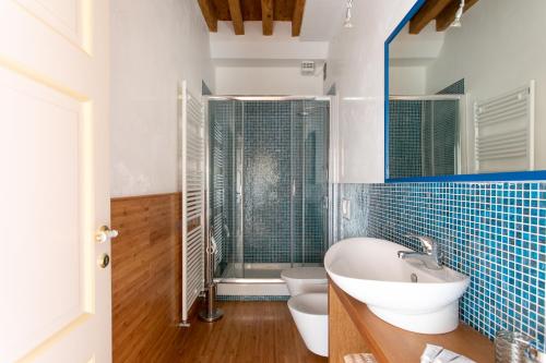 a bathroom with a sink and a toilet and a shower at Wondrous Palazzetto 1619 in Magical Burano Island in Burano