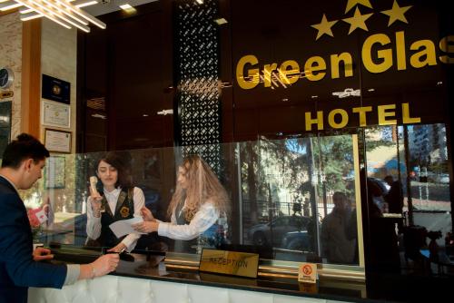 a group of people standing in front of a green glass hotel at Hotel Green Glass in Batumi