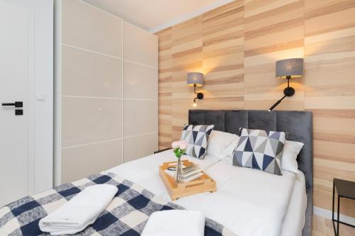 um quarto com uma cama e uma parede de madeira em Lux Family Apartment Nadmorskie Tarasy by Renters em Gdynia