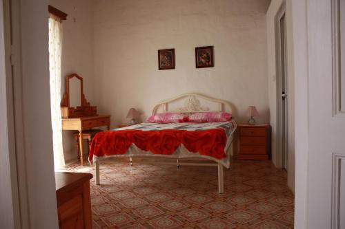 a bedroom with a bed with a red blanket on it at VERTICAL CLIMBING MALTA in Qrendi