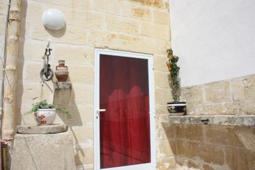 una puerta con una cortina roja en el lateral de un edificio en VERTICAL CLIMBING MALTA, en Qrendi
