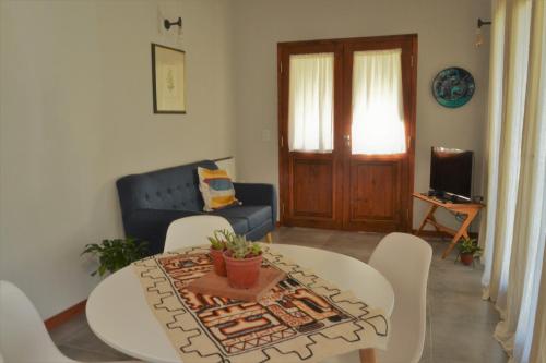 sala de estar con mesa y sofá azul en Casa Lali en Lago Puelo