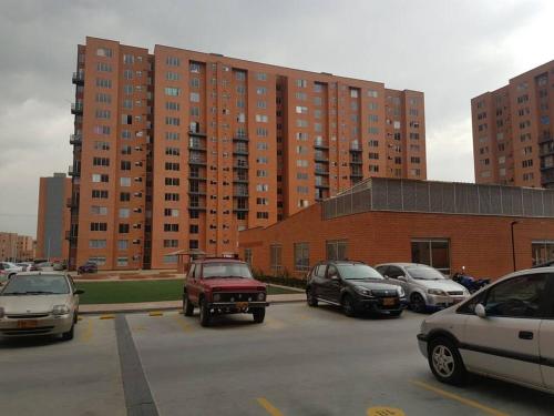 a parking lot with cars parked in front of tall buildings at Apartamento amoblado Central 148 in Bogotá
