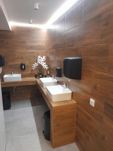 a bathroom with two sinks and a tv on the wall at SCHRONISKO GOŚCINIEC RÓWNICA in Ustroń