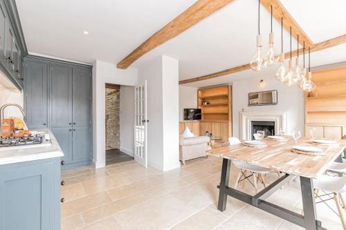 a kitchen and dining room with a wooden table and a dining room at Oxfordshire Living - The Vanbrugh Apartment - Woodstock in Woodstock