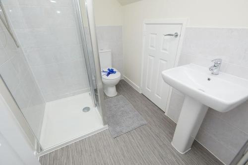 a bathroom with a toilet and a sink and a shower at Prime Location & Free Parking Stylish 3-Bed Home in Leicester