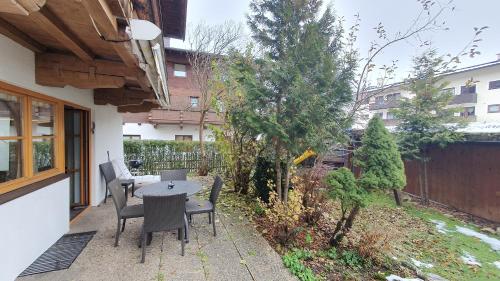 a patio with a table and chairs in a backyard at Haus Monika in Kirchberg in Tirol