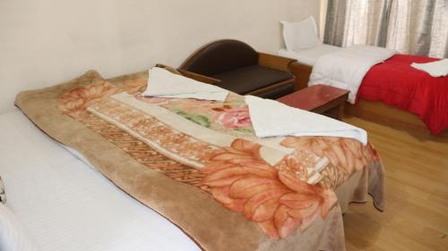 a room with a bed and a chair in a room at Siala Guest House in Leh