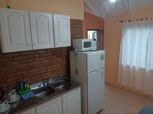 a kitchen with a white refrigerator and a microwave at UAKEN CABAÑAS in El Calafate