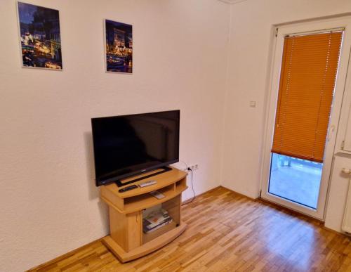 a flat screen tv sitting on a wooden stand in a room at Apartmani Bugojno in Bugojno