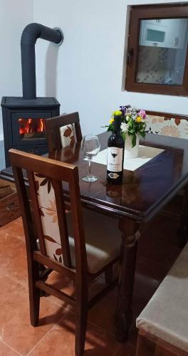 a table with a bottle of wine and a glass at Etno kuca Ostrvica 2 in Varnice