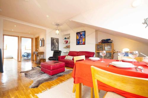 a living room with a red table and a couch at Las Gaviotas Playa By Silastur in Gijón