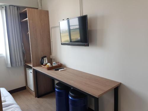 a room with a table with a tv on the wall at SLEEP TO FLY HOTEL & HOSTEL suvarnabhumi airport in Bangkok