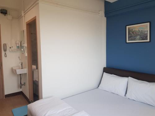 a bedroom with a white bed with a blue wall at SLEEP TO FLY HOTEL & HOSTEL suvarnabhumi airport in Bangkok