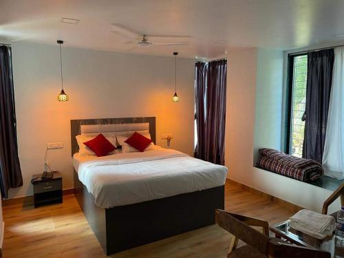 a bedroom with a bed with red pillows on it at Bliss Rooms in Alibaug