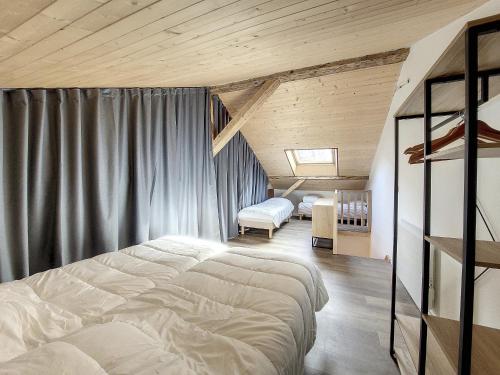 sypialnia z 2 łóżkami w pokoju z drewnianym sufitem w obiekcie Green Marmottes Chalet - 12 personnes - Pied des pistes - Saint Jean D Aulps w mieście Saint-Jean-dʼAulps