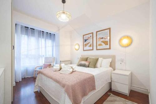 ein weißes Schlafzimmer mit einem Bett und einem Fenster in der Unterkunft Camino a la Playa in Gijón