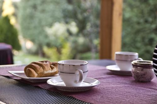 two cups of coffee and a plate of donuts on a table at Guest House Via in Bitola