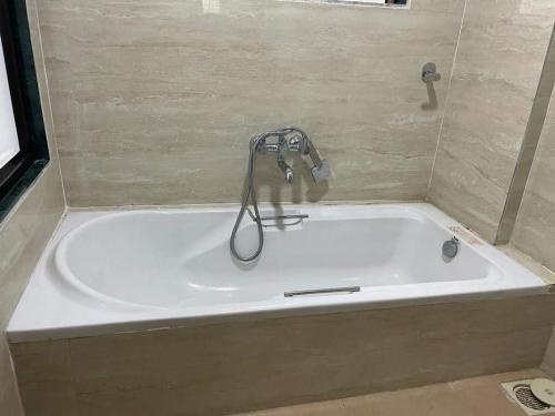 a bath tub with a faucet in a bathroom at Bliss Rooms in Alibaug